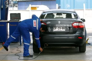 hombre realizando revisión técnica a automóvil en Chile